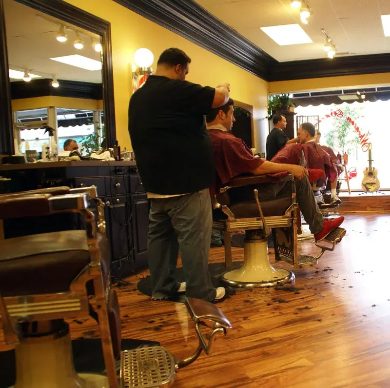 Barber cutting hair with clippers at Wheaton Barber Shop in Winfield