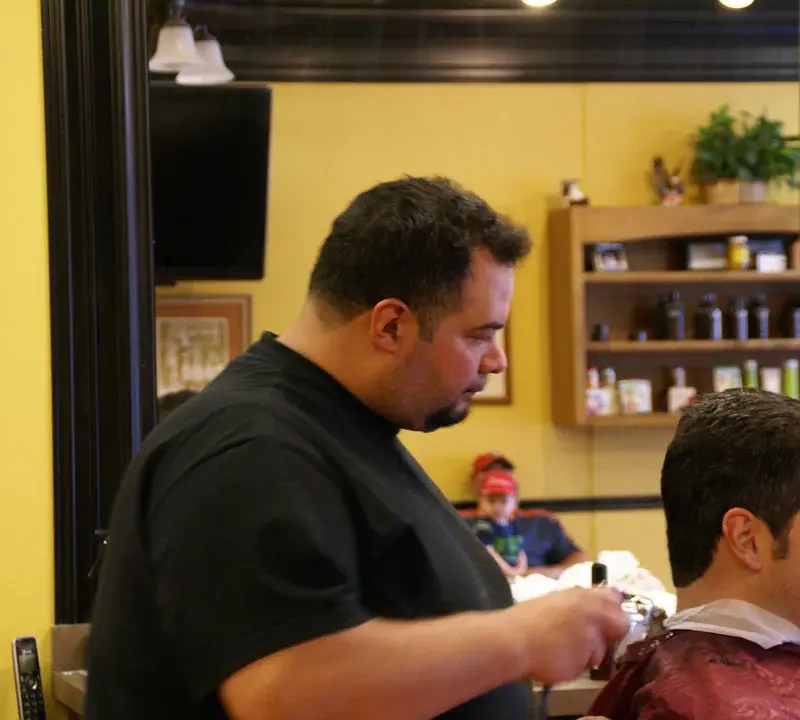 Barber finishing a men's clipper cut at Wheaton Barber Shop