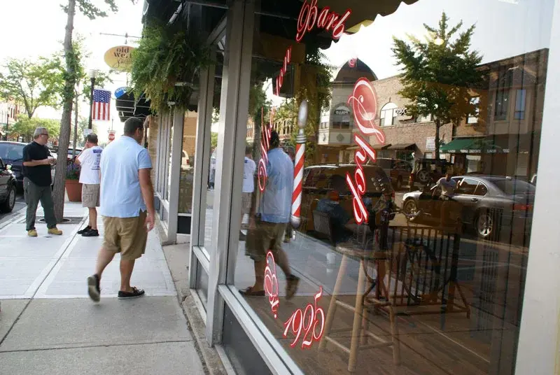 Downtown sidewalk view of the Wheaton Barber Shop storefront