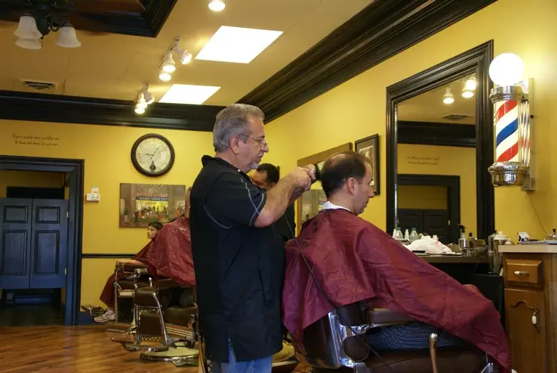 Men's haircut next to the classic barber pole at Wheaton Barber Shop Winfield