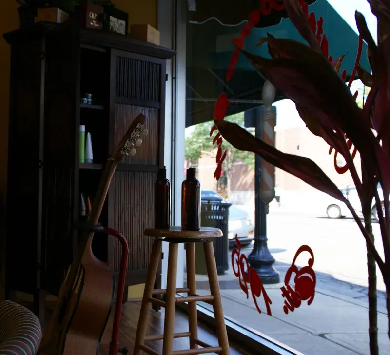 Window display inside Wheaton Barber Shop with barber pole artwork