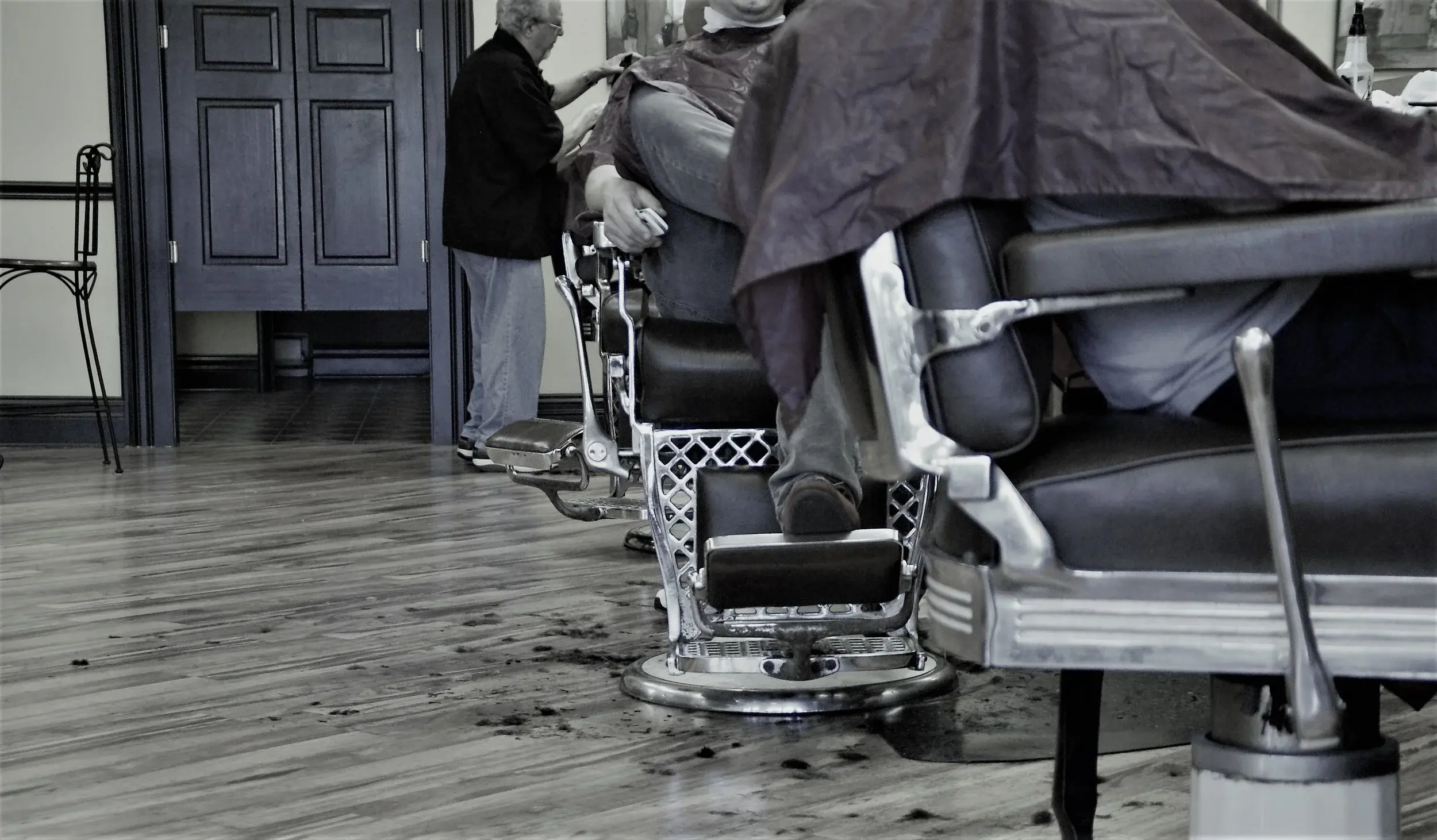 Barbers cutting hair while a customer waits at Wheaton Barber Shop Winfield IL