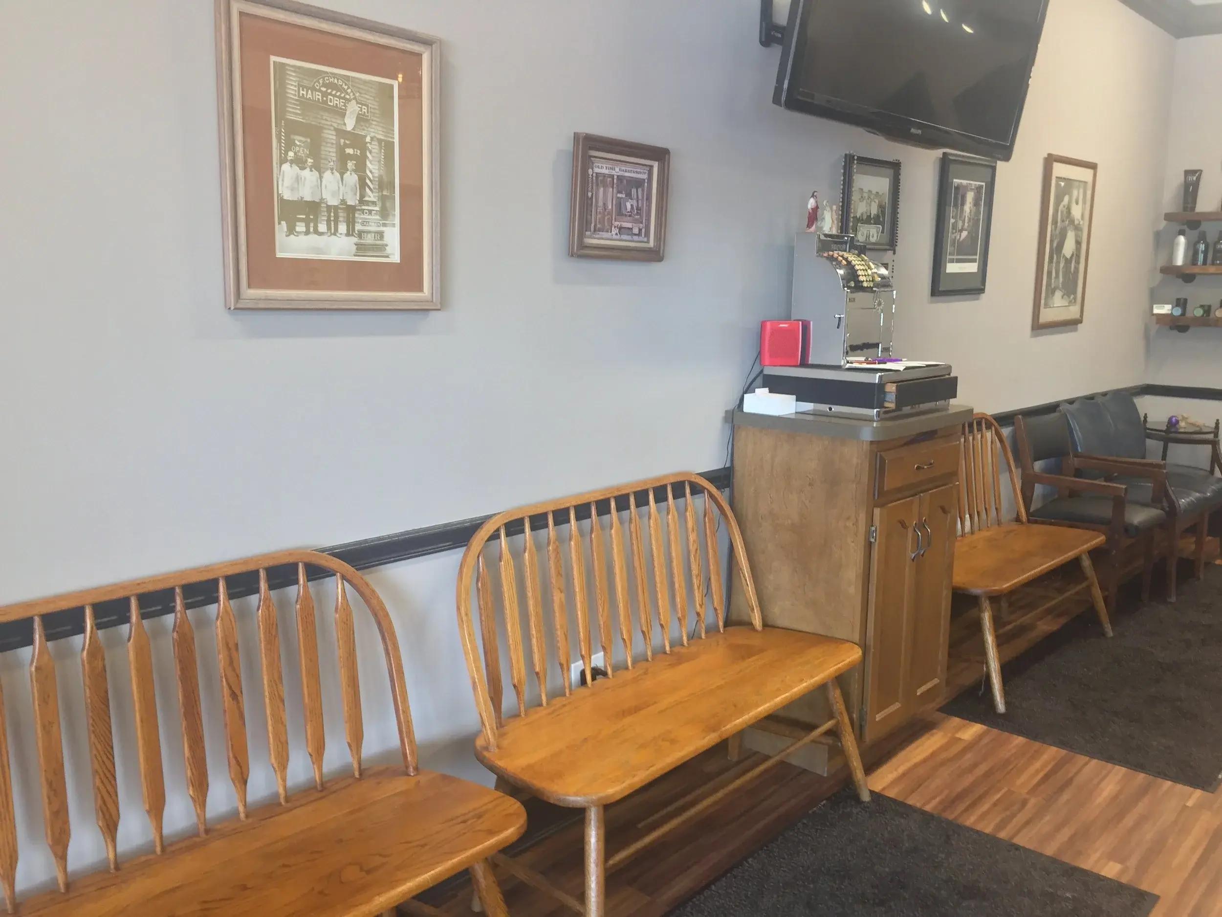 Wheaton Barber Shop waiting area with wooden benches and historic barber photos