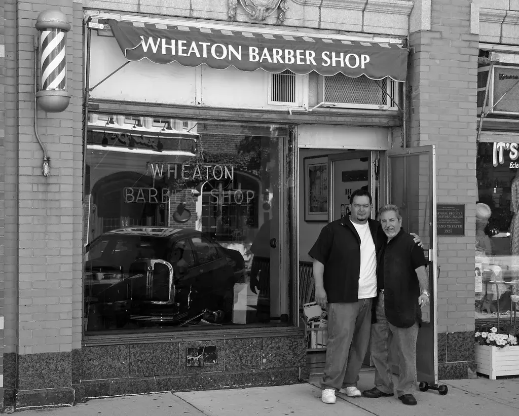 Two barbers outside the original Wheaton Barber Shop location in DuPage County